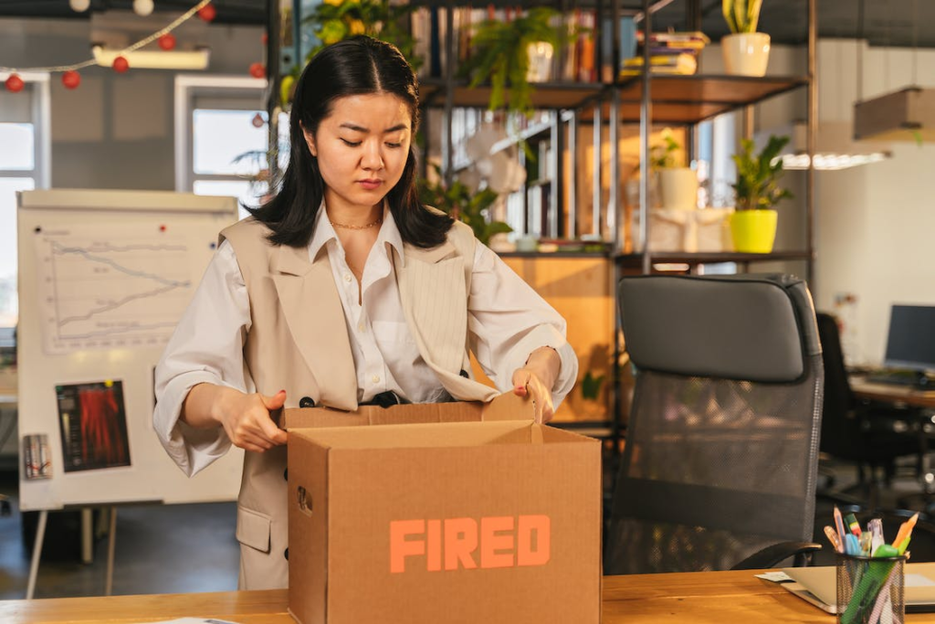 woman packing things after being fired from office