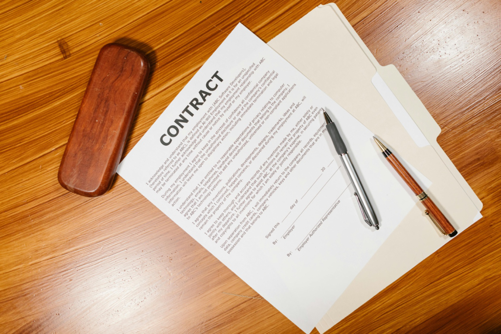 An Unsigned Employment Contract with Biro on a Wooden Surface