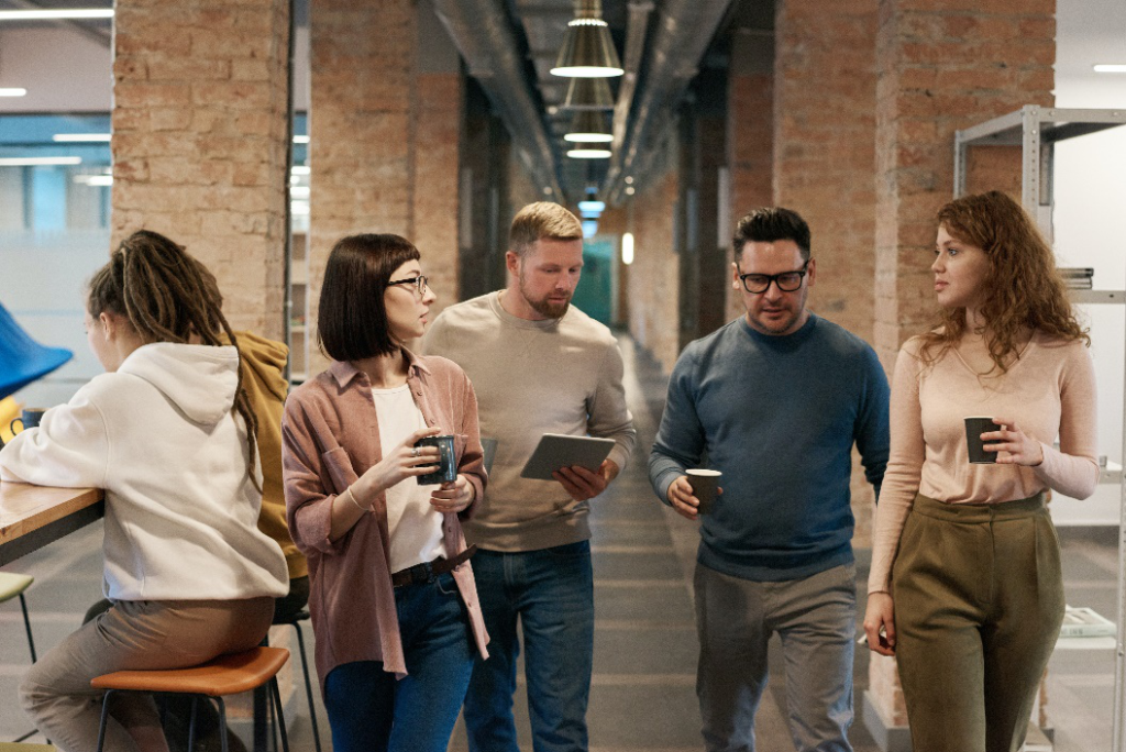 People walking with coffees in an office