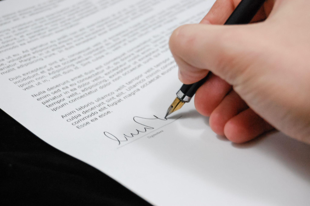 Closeup of a person signing papers