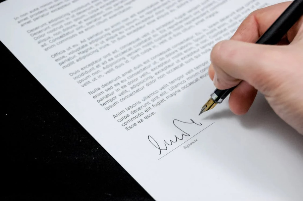 An image of a person signing an agreement